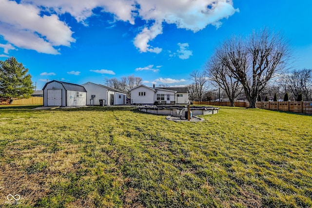 back of property with a fenced in pool, a fenced backyard, an outdoor structure, a storage unit, and a lawn