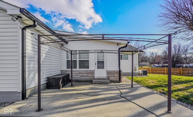 view of patio with entry steps, central AC unit, and fence