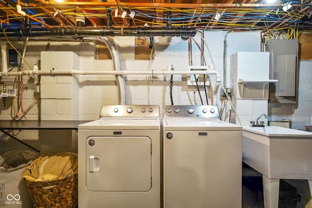 laundry area featuring washer and dryer, laundry area, electric panel, and a sink