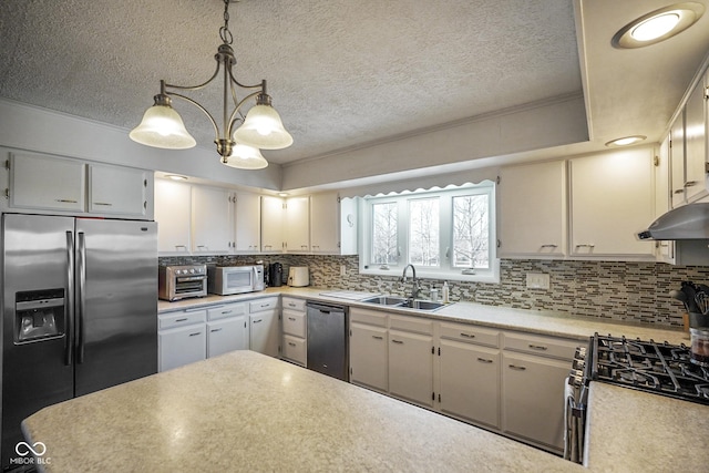 kitchen with light countertops, tasteful backsplash, appliances with stainless steel finishes, and a sink