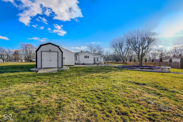 view of yard with fence, an outbuilding, and a shed