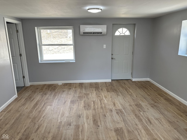 entryway featuring a wall mounted air conditioner, baseboards, and wood finished floors