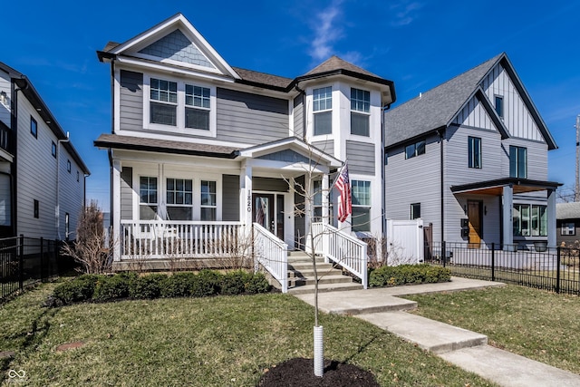 view of front of house featuring board and batten siding, a porch, fence, and a front yard