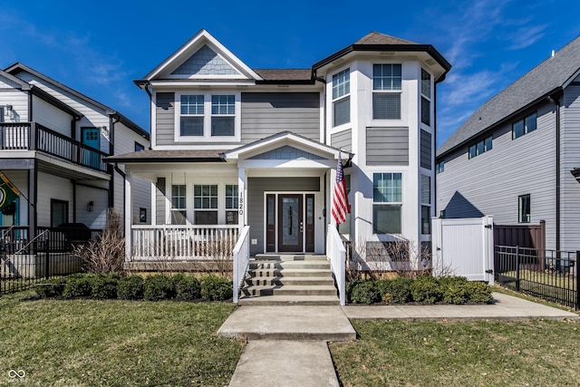 view of front of house featuring a porch, a front yard, and fence