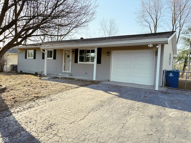 ranch-style house featuring aphalt driveway, a garage, and central AC