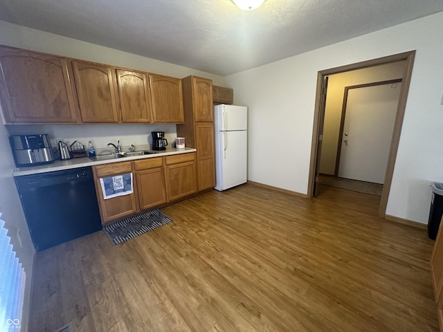8 Gladiator Dr, Waynetown, IN 47990 - kitchen with a sink, light wood-style floors, black dishwasher, light countertops, and freestanding refrigerator