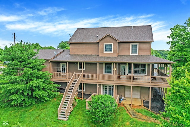 back of property featuring a wooden deck, a shingled roof, stairs, and a yard