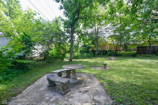 view of yard featuring a patio, fence, and an outdoor fire pit