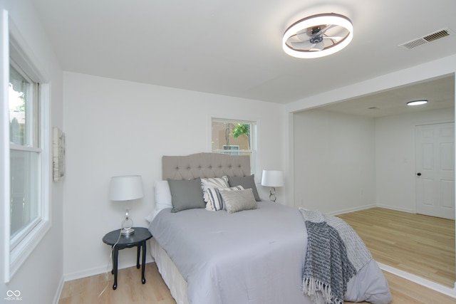 bedroom with light wood-style flooring, baseboards, and visible vents