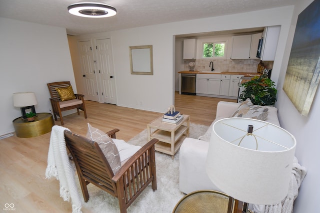 living area featuring a textured ceiling and light wood finished floors