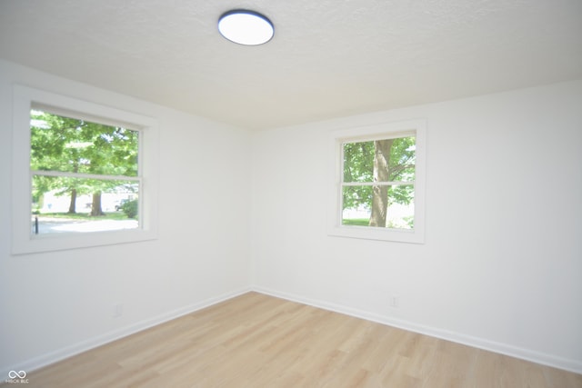 empty room with light wood finished floors and baseboards