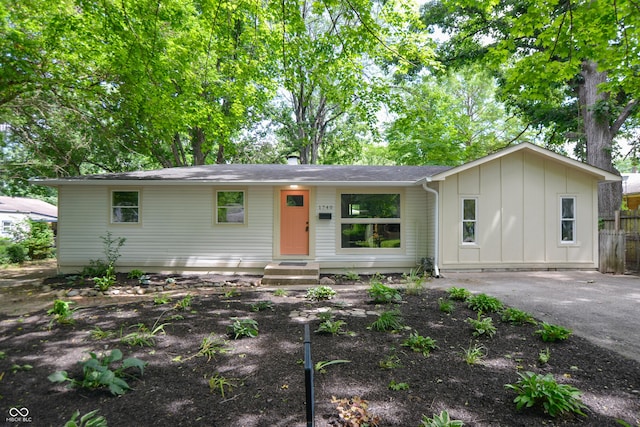 ranch-style house with board and batten siding and fence