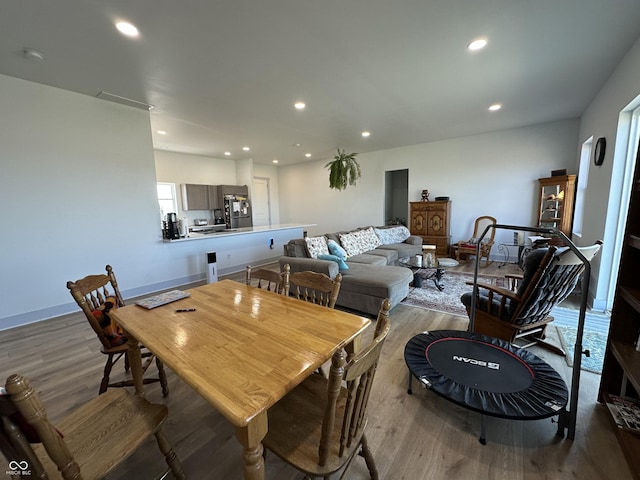 dining area featuring recessed lighting, wood finished floors, and baseboards