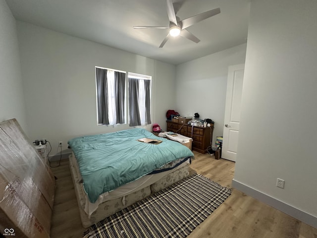 bedroom featuring light wood finished floors, ceiling fan, and baseboards