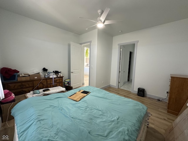 bedroom with ceiling fan, baseboards, and light wood-style flooring