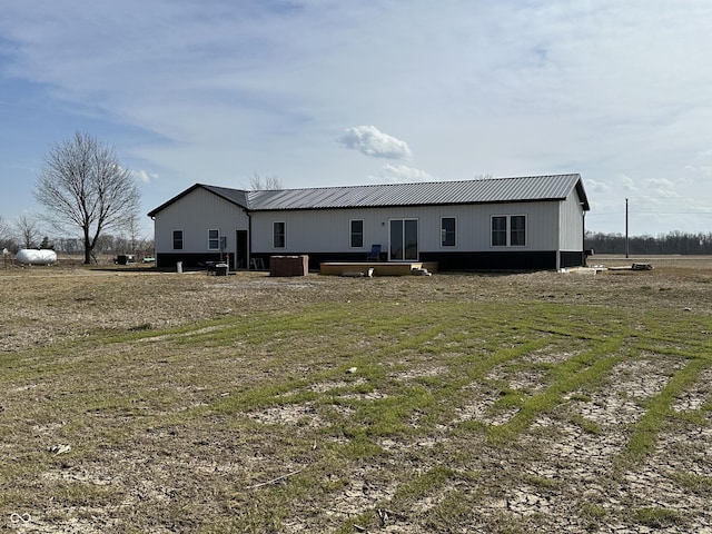 rear view of house with metal roof and central AC