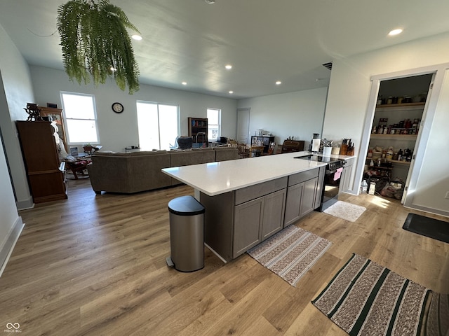 kitchen with recessed lighting, light wood-style flooring, gray cabinetry, and light countertops