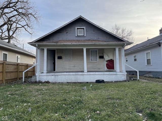 view of front facade featuring a porch, fence, and a front yard