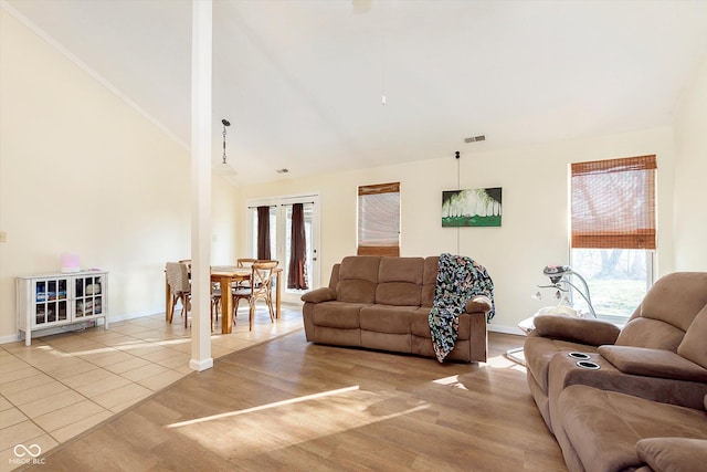 living area featuring visible vents, baseboards, high vaulted ceiling, and wood finished floors