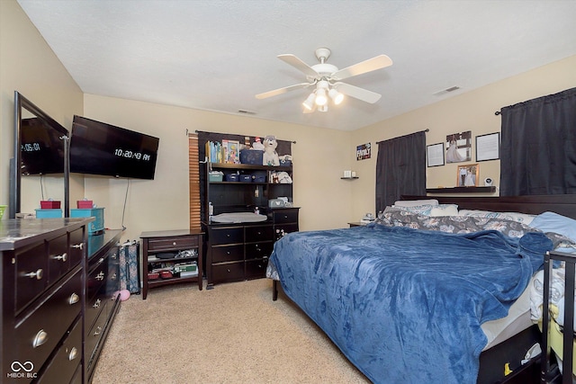 bedroom featuring visible vents, light carpet, and a ceiling fan