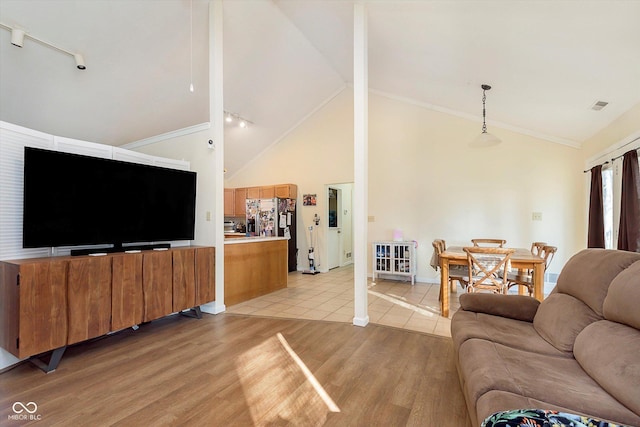 living room with visible vents, high vaulted ceiling, crown molding, and light wood finished floors