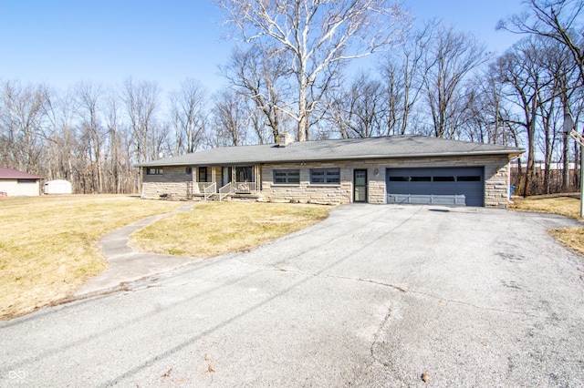 view of front of home featuring aphalt driveway, stone siding, a garage, and a front lawn