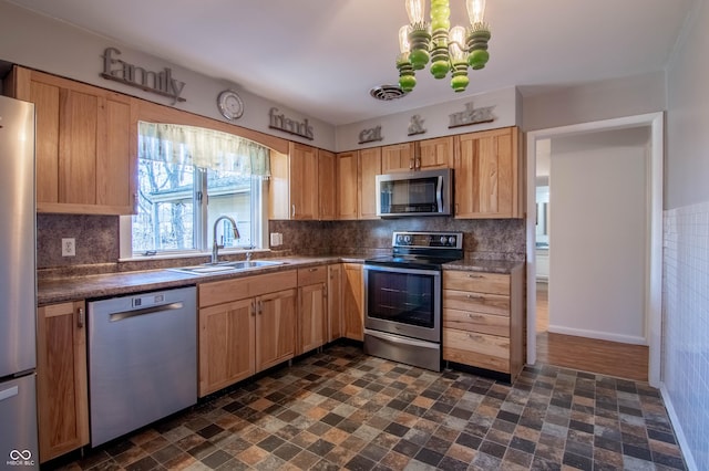 kitchen with dark countertops, visible vents, light brown cabinetry, stainless steel appliances, and a sink