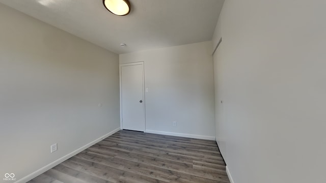 empty room with baseboards and wood finished floors