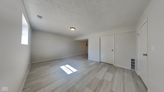 unfurnished bedroom with visible vents, baseboards, and a textured ceiling