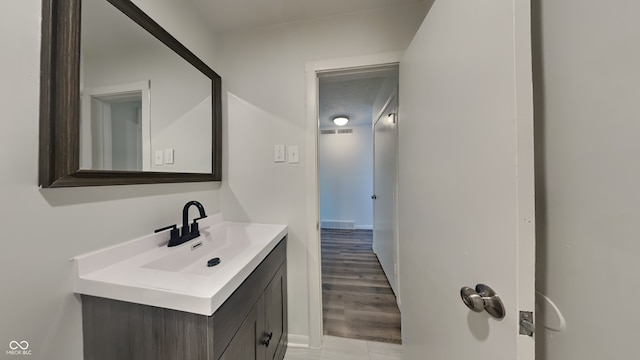 bathroom featuring visible vents, wood finished floors, and vanity