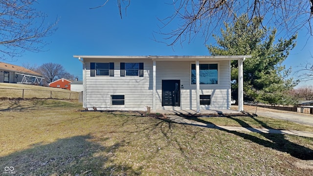 raised ranch with a front yard and fence