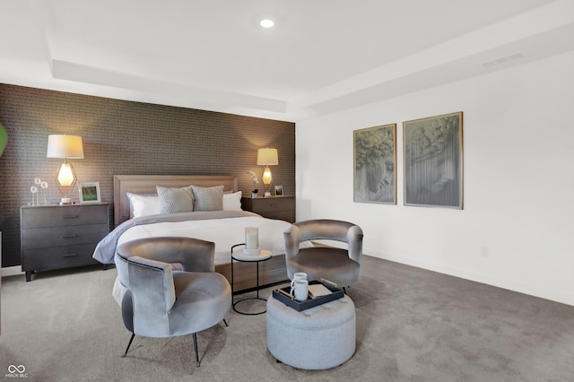 bedroom with carpet, a raised ceiling, baseboards, and an accent wall