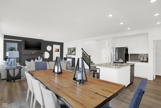 dining space with recessed lighting, stairway, and wood finished floors