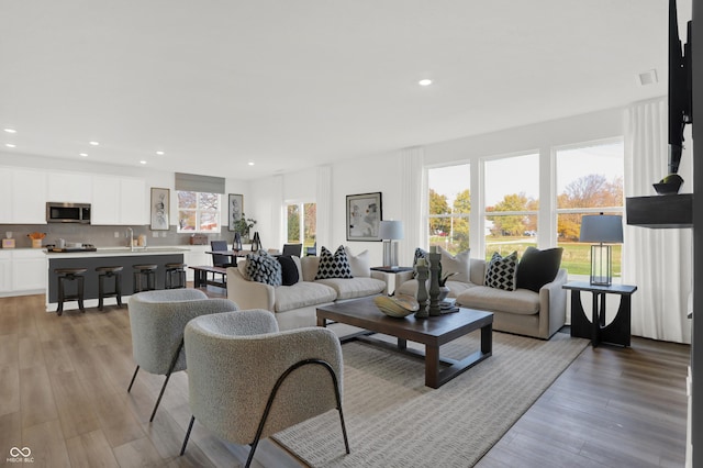 living area featuring recessed lighting, visible vents, and light wood finished floors