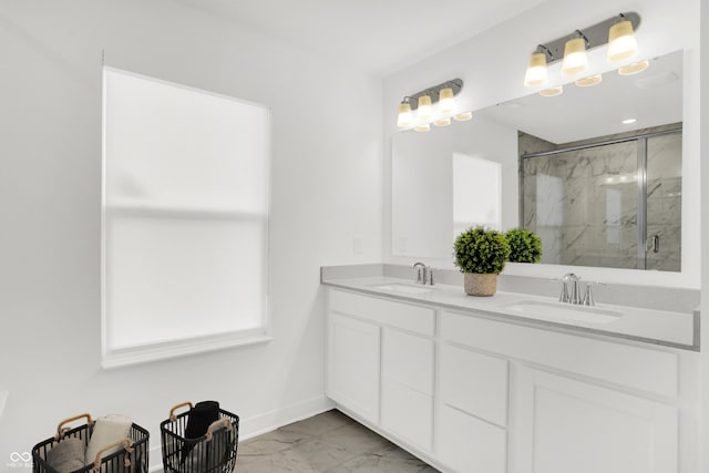 full bathroom featuring a marble finish shower, marble finish floor, double vanity, and a sink