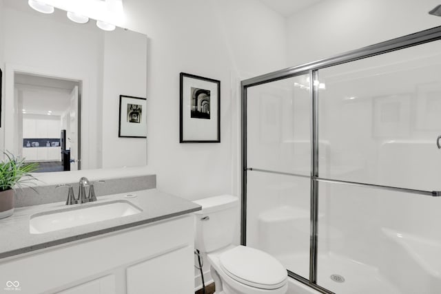 full bathroom with a shower stall, toilet, and vanity