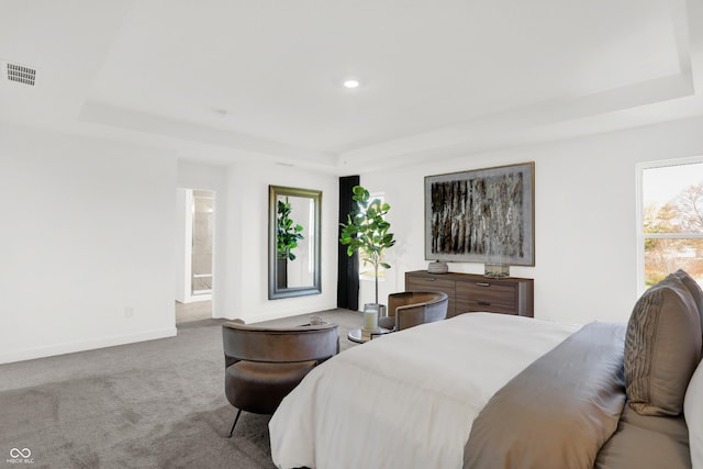 carpeted bedroom with recessed lighting, a tray ceiling, baseboards, and visible vents