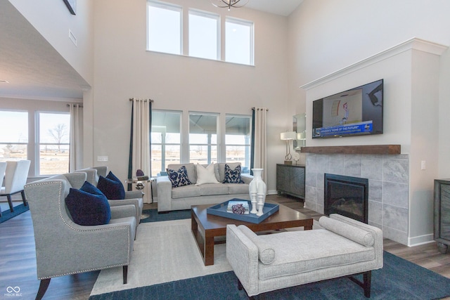 living room with baseboards, plenty of natural light, wood finished floors, and a fireplace