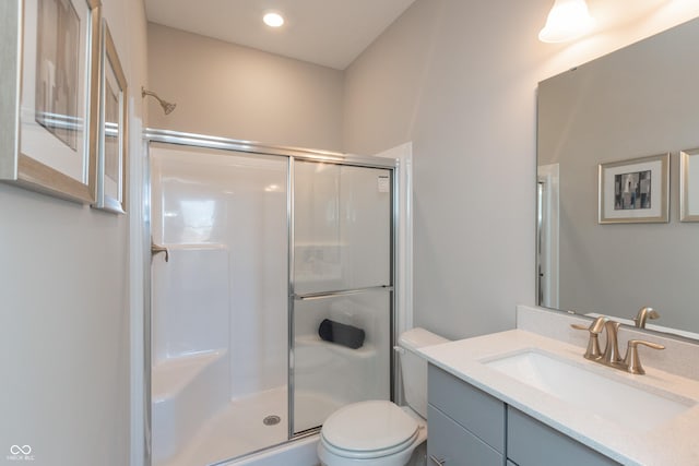 bathroom with vanity, toilet, and a shower stall