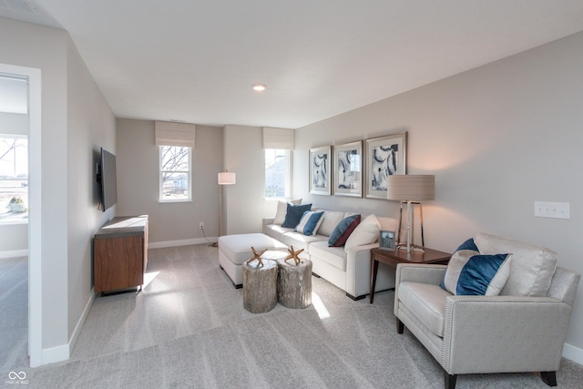 living area featuring visible vents, light colored carpet, and baseboards