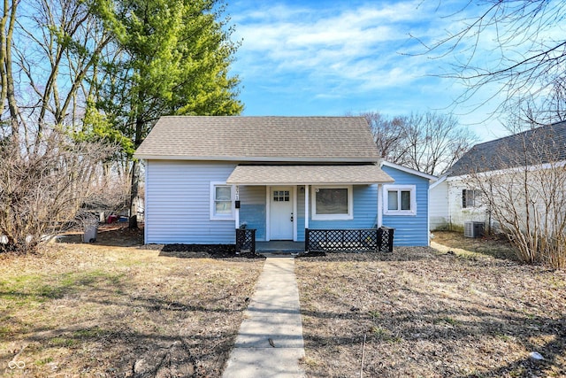 bungalow featuring a porch, cooling unit, and a shingled roof