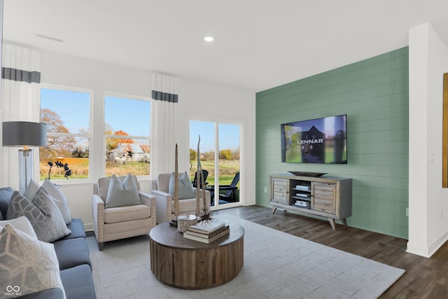 living area with plenty of natural light, recessed lighting, visible vents, and wood finished floors