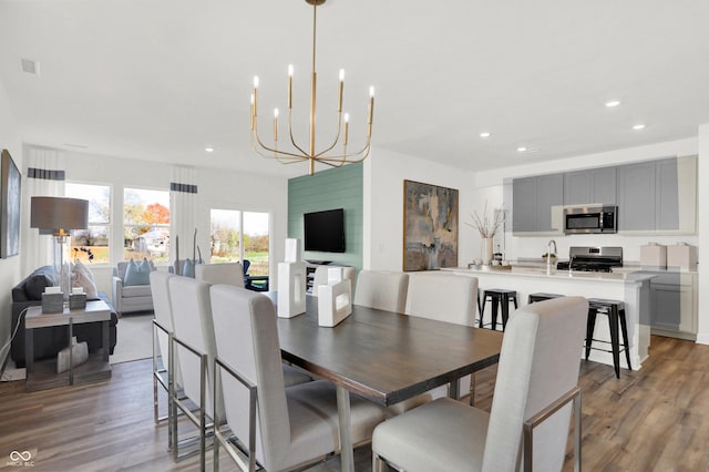 dining area with recessed lighting, visible vents, light wood-style floors, and an inviting chandelier