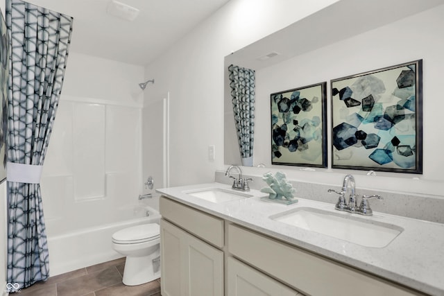 bathroom with double vanity, shower / washtub combination, toilet, and a sink