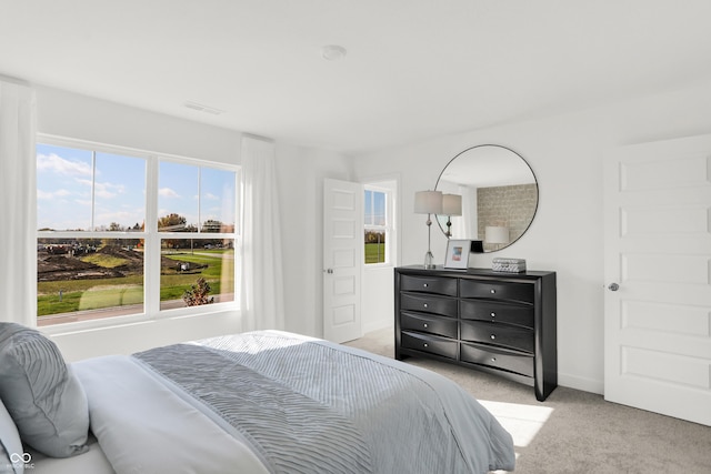 bedroom with visible vents, light colored carpet, and baseboards