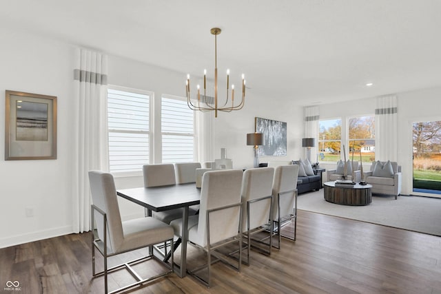 dining space featuring baseboards, an inviting chandelier, and dark wood-style flooring