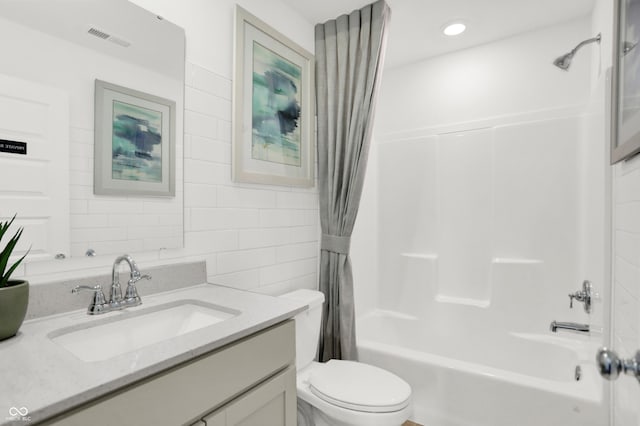 bathroom with visible vents, toilet, vanity, tile walls, and shower / bathtub combination with curtain