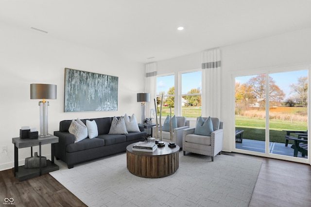 living room with recessed lighting, wood finished floors, visible vents, and baseboards