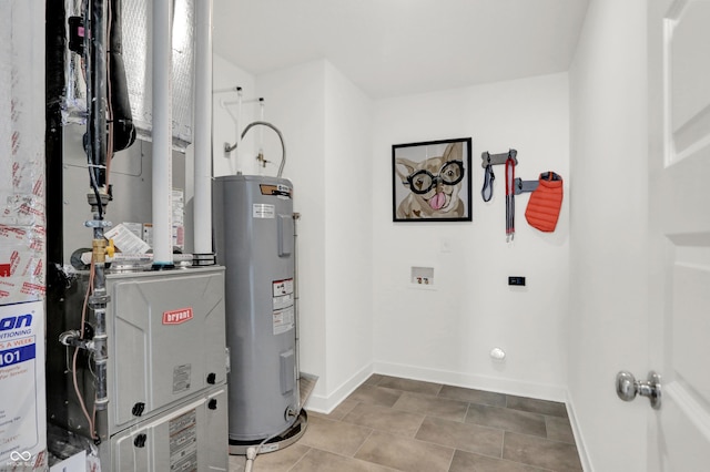 utility room with heating unit and electric water heater