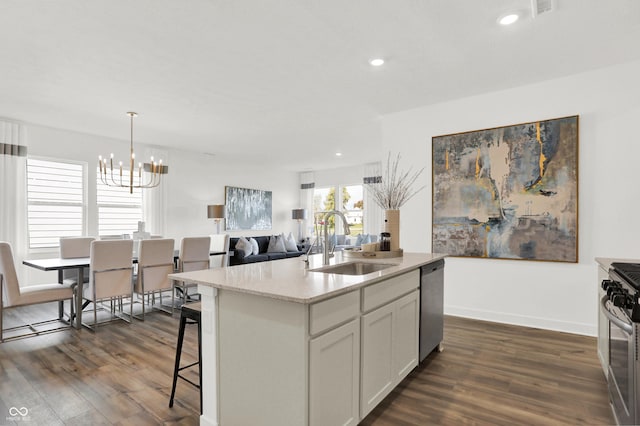 kitchen with an inviting chandelier, dark wood-style flooring, appliances with stainless steel finishes, and a sink